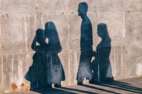 A family's shadows shown on wall. Photo by Igor Ovsyannykov on Unsplash