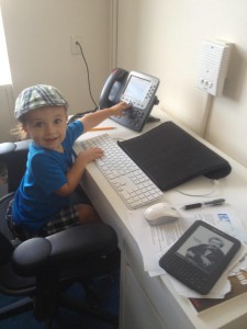 Isaac’s son Caleb sees where his Dad works, promptly gets on Dad’s chair and starts making calls. Summer 2013.