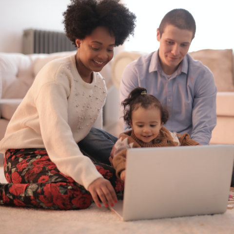 Two parents with child looking at computer