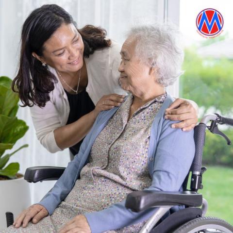 Female caregiver with elderly woman in wheelchair