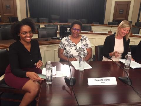 [IMAGE DESCRIPTION: Three women sit at a dark wooden table in Congress.]