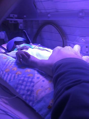 Preemie baby, holding parent's thumb.