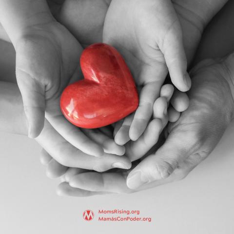 Black and white hands holding a red heart