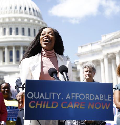 A woman speaking at a podium in front of the capitol