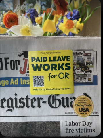 Newspaper with yellow sticker that reads "Paid Leave Works for Oregon" flowers in the background.