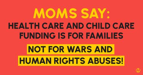 A protester holding a sign that reads 'Health Care Not War' during a rally against budget cuts.