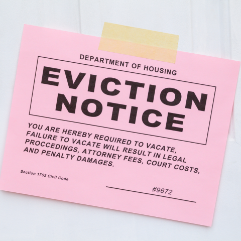 Pink eviction notice taped to a door.