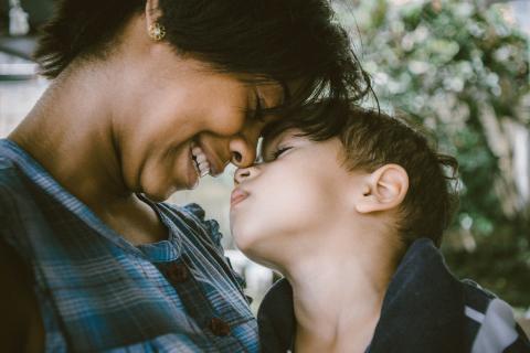 A woman lovingly holds a little boy