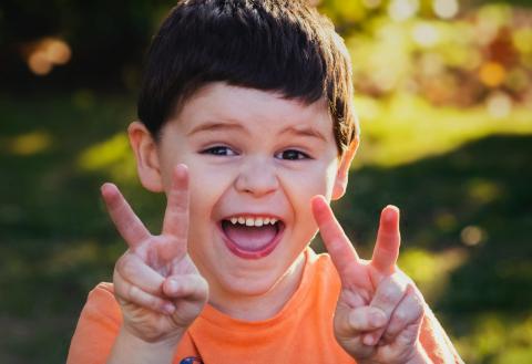 Photo of young child giving peace signs