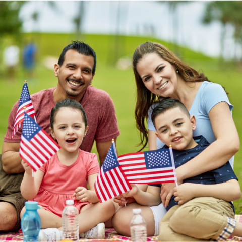 Latinx-American family holding U.S. flags