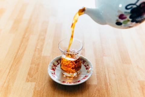 person pouring tea into a cup