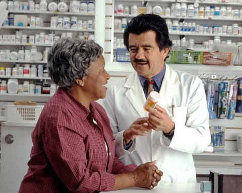 Pharmacist is showing medication to an older woman. 