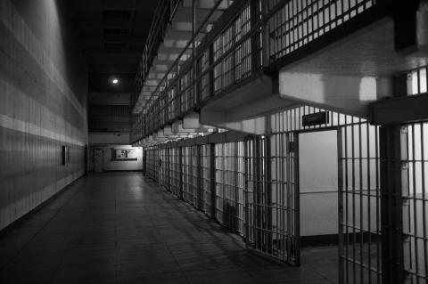 [IMAGE DESCRIPTION: A black and white photo of an empty hallway in a prison, with a wall on the left.]