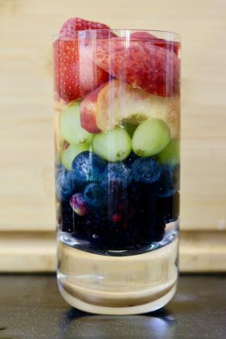 [IMAGE DESCRIPTION: A glass filled with layers of fruit arranged in rainbow color order.]