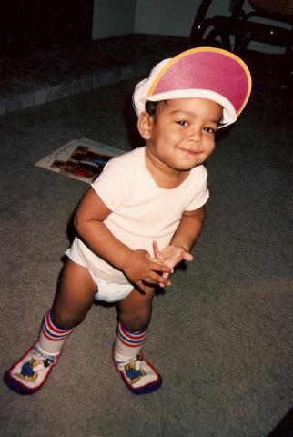 Baby Samuel in pampers smiling at the camera.