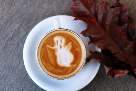photo of white teacup filled with ghost illustration in foam