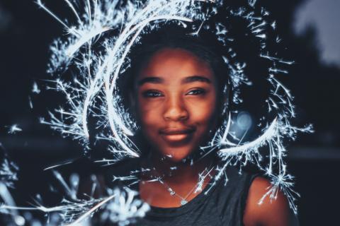 photo of a woman illuminated by sparklers