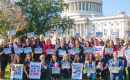 A diverse group of women holding signs in front of the US Capitol