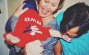 Two white parents playing with a baby