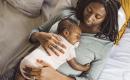 Close-up of a Black mother and sleeping baby, capturing a quiet moment of intimacy and joy.