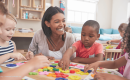 Child care teacher and children learning and playing together.