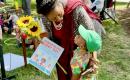 A baby Riser gives a MomsRising storybook to Rep. Sheila Jackson Lee