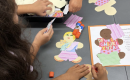 Children creating paper dolls at MomsRising Mombassador and RISER Jean's immigration-themed story 