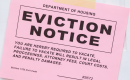 Pink eviction notice taped to a door.