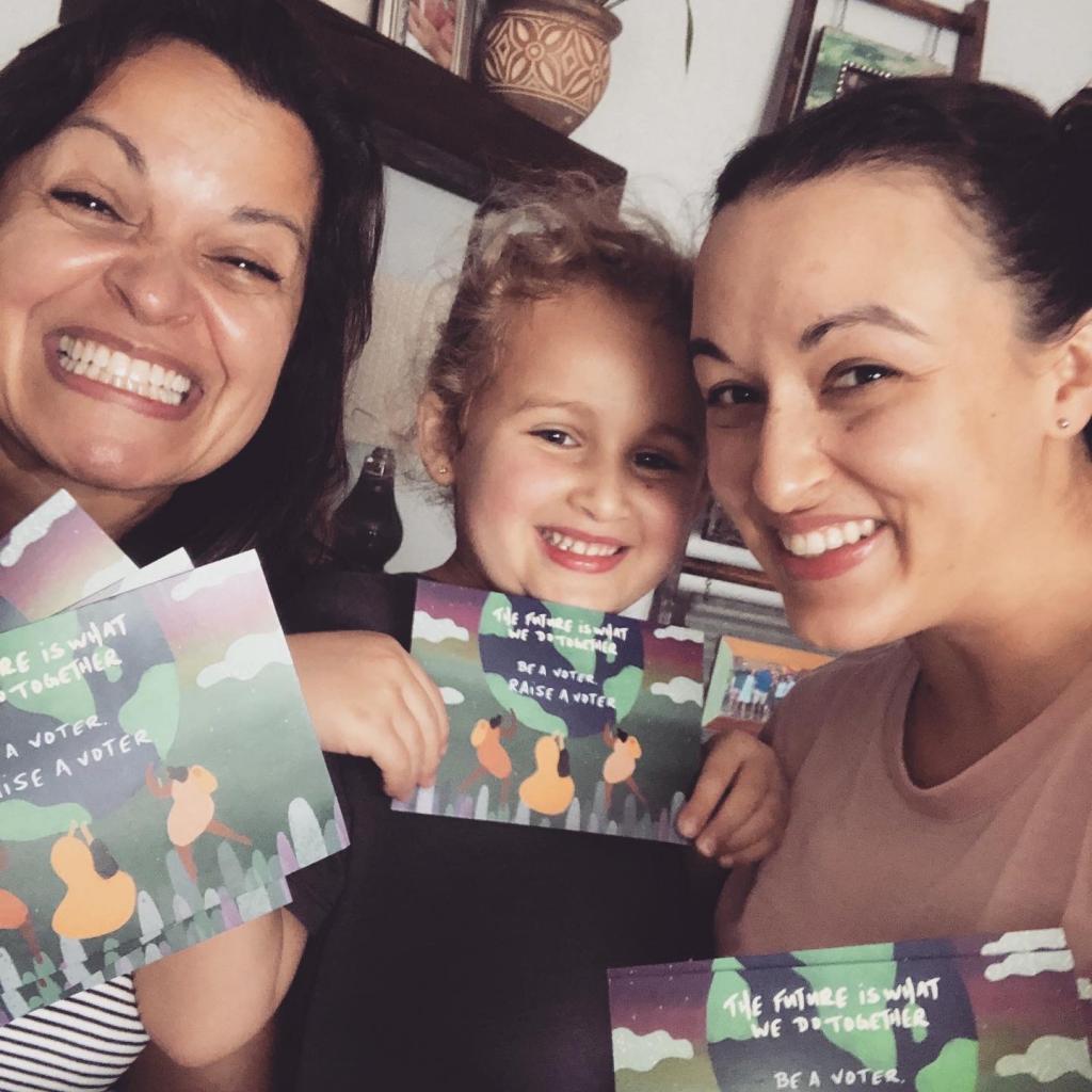 Photo of a 3 generations of volunteers with their MomsVote voter postcards 2020