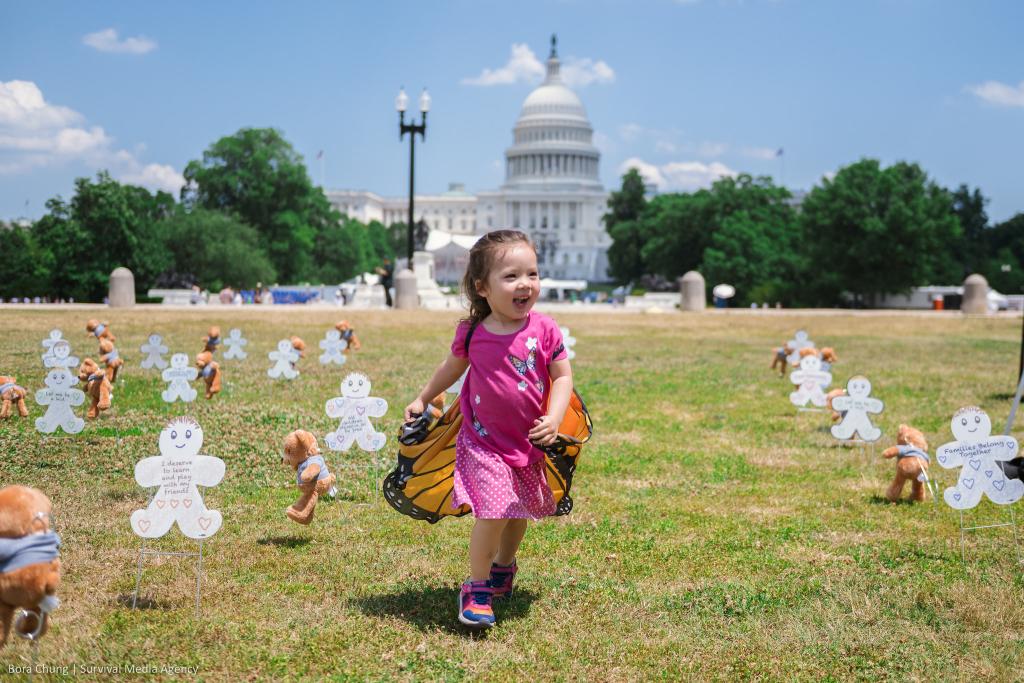 MomBassador Jean's daughter wearing butterfly wings at the "Fund Care, Not ICE" event