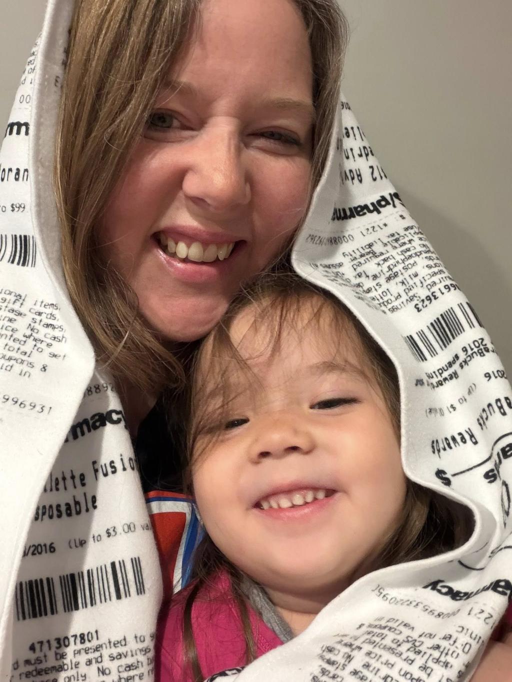 Jean with her child with a receipts scarf wrapped around them