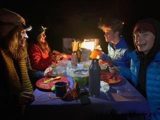 [IMAGE DESCRIPTION: A photo of a family sitting at a table with a purple tablecloth and a fireplace in the background.]