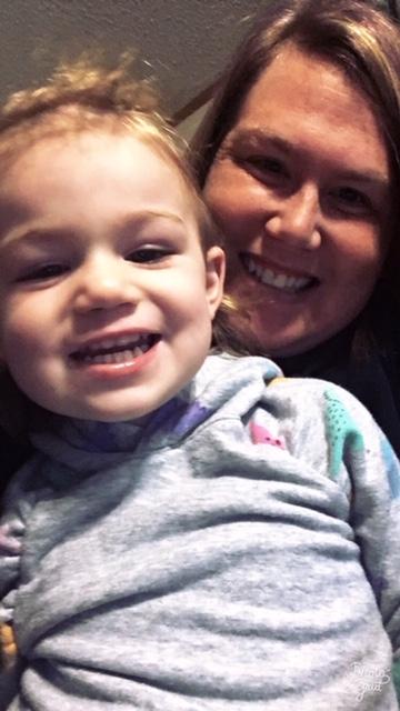 [IMAGE DESCRIPTION: An adult with shoulder length dark hair holds a child; both look smiling at the camera.]