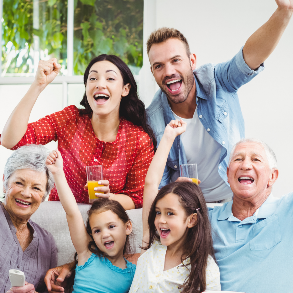 Family facing camera and raising arms like they are cheering.