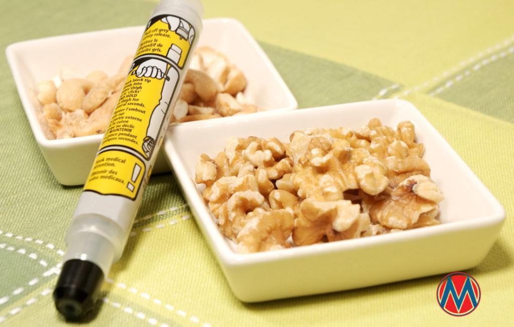Epipen next to two bowls of assorted nuts