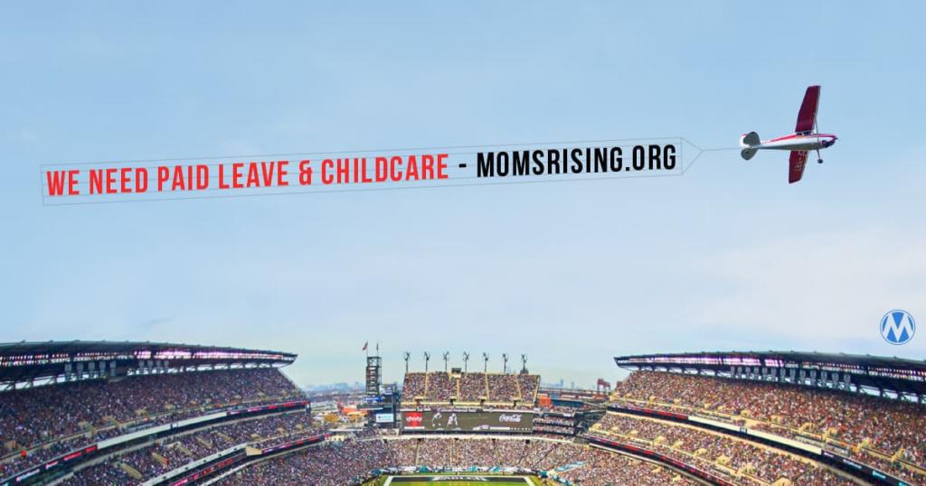 Airplane flying over a football stadium with a banner that reads "We Need Paid Leade & Child Care" -Momsrising.org
