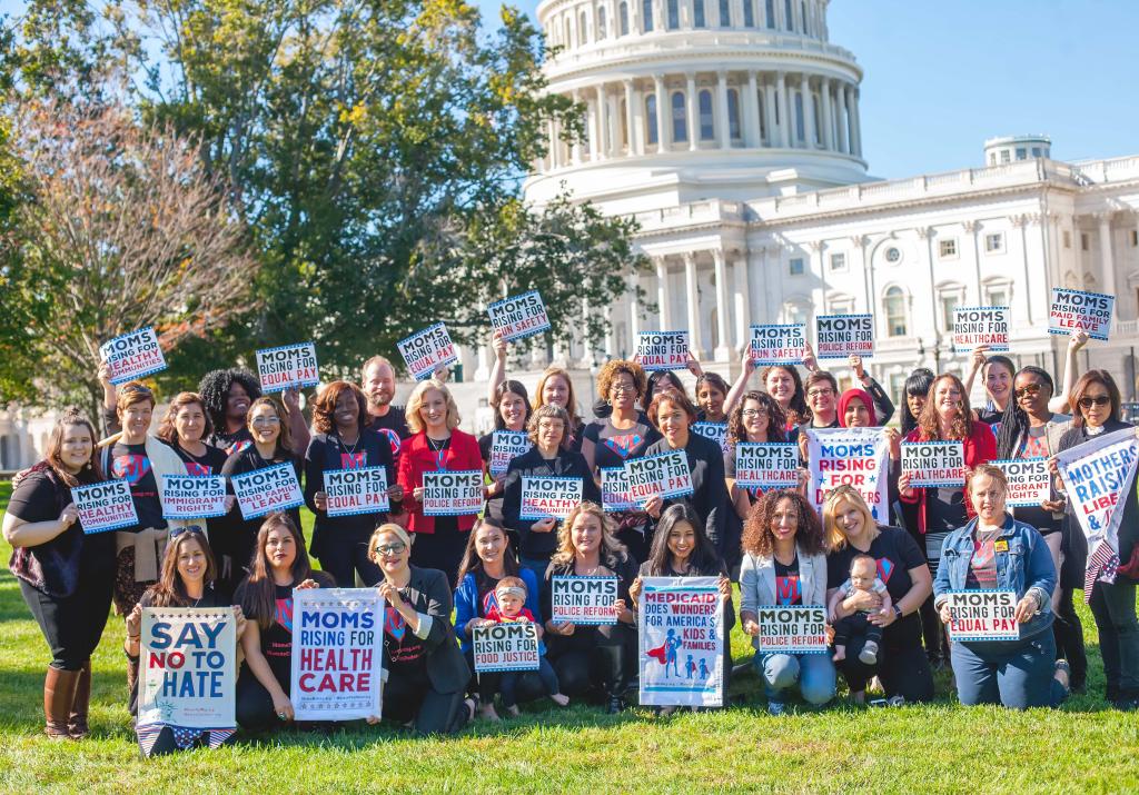 MomsRising staff holding signs in front of the Capitol