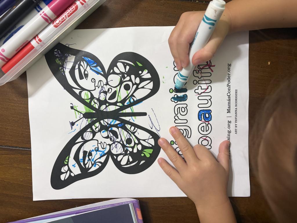 Children coloring in a butterfly with blue marker
