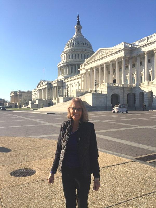 [IMAGE DESCRIPTION: A photo of a woman smiling in front of the US Capitol in Washington DC.]