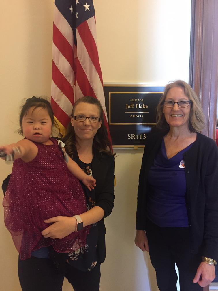 [IMAGE DESCRIPTION: A photo of two women, one holding a toddler, outside US Senator Jeff Flake's Senate office.]