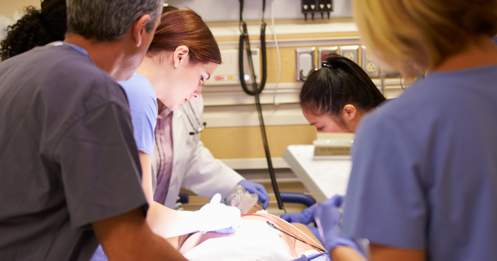 [photo of medical professionals tending to a patient with a nurse in the foreground]