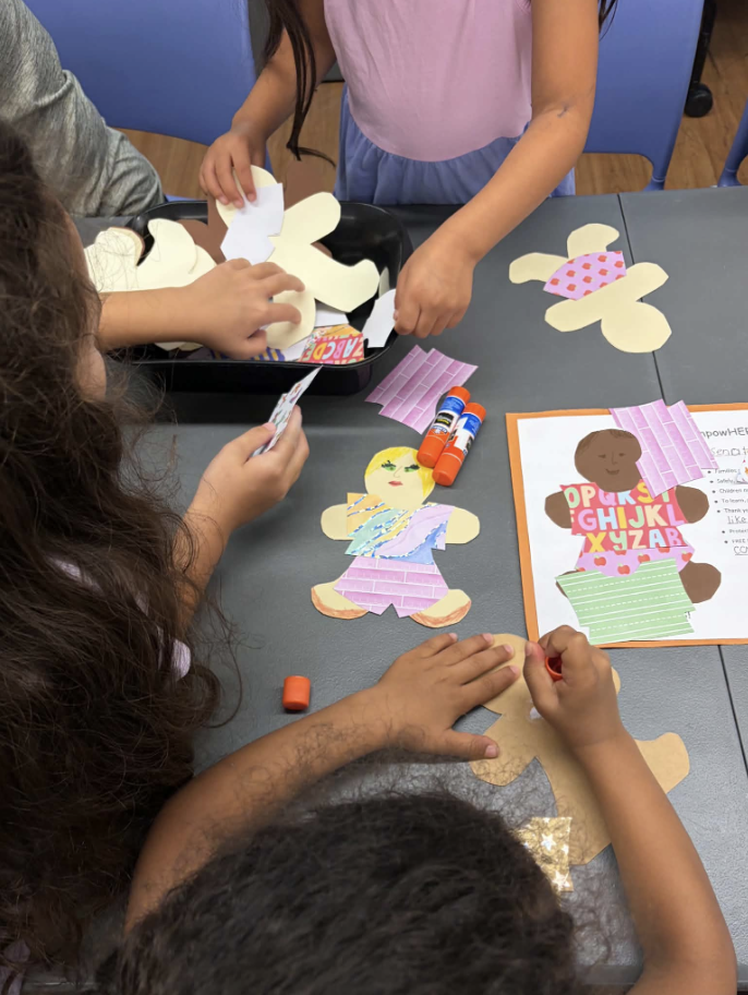 Children creating paper dolls at MomsRising Mombassador and RISER Jean's immigration-themed story 