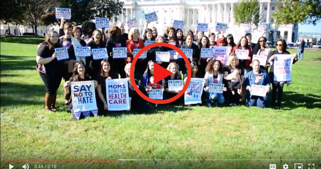 [IMAGE DESCRIPTION: A screenshot from a video with a group of people outside the US Capitol, holding MomsRising signs.]