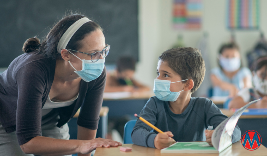 A teacher and student wearing a mask