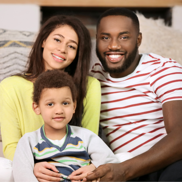 Young parents with brown skin sitting with their son