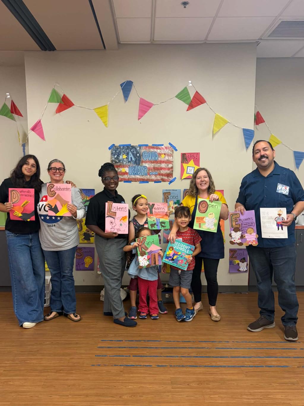 Participants in Jean's Kids Caucus event smiling and holding books