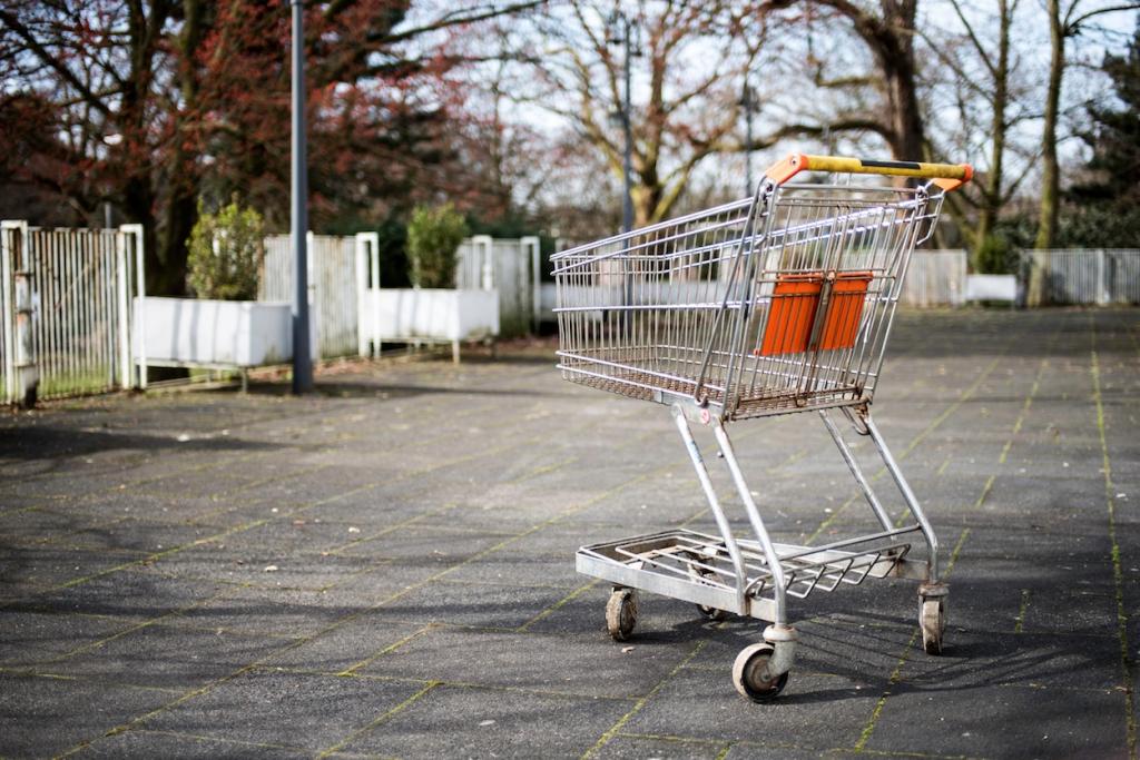 Photo by Kai Oberhäuser on Unsplash. Photo Description: Empty grocery shopping cart on a sidewalk. 