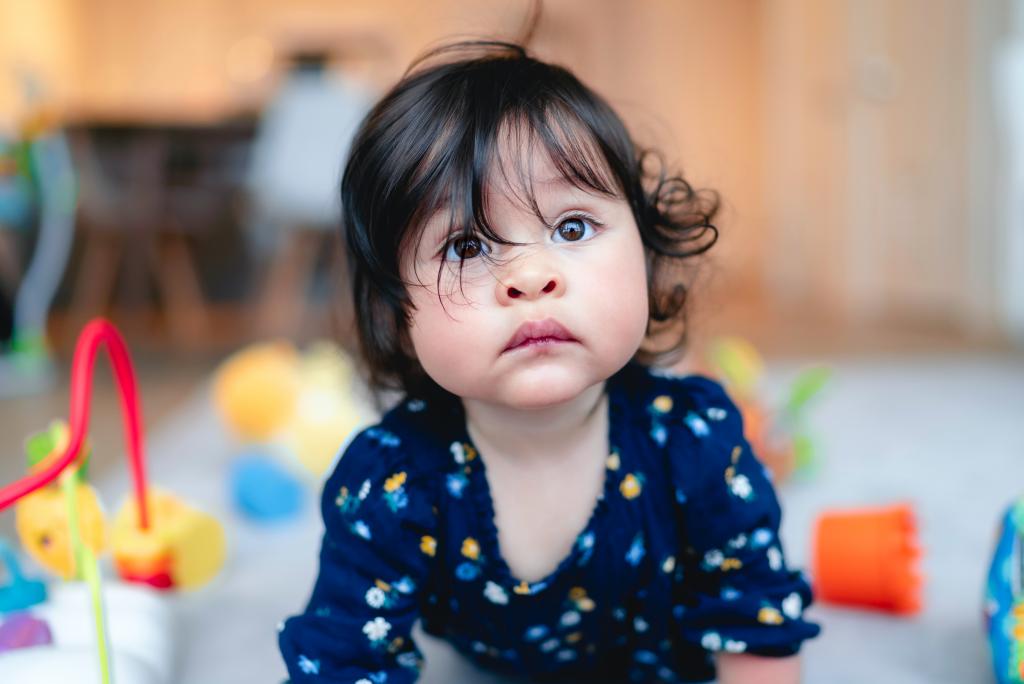 Toddler crawling on carpet, looking up. 