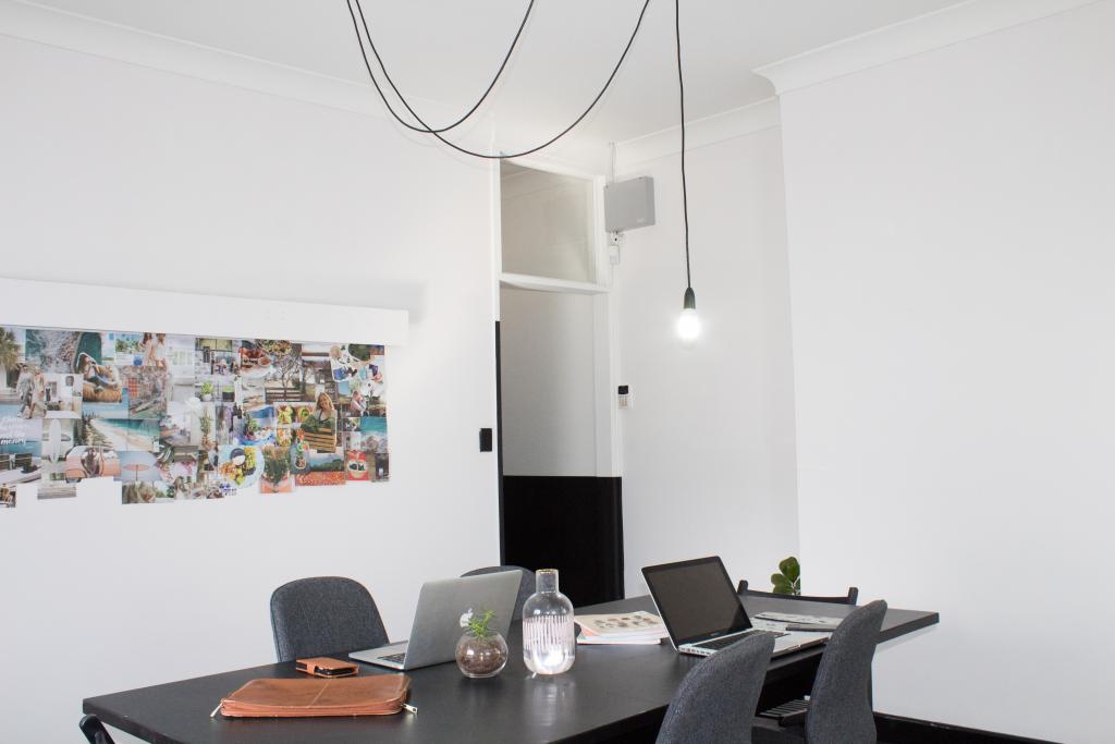 [IMAGE DESCRIPTION: A photo of a black desk with two laptops on it.]