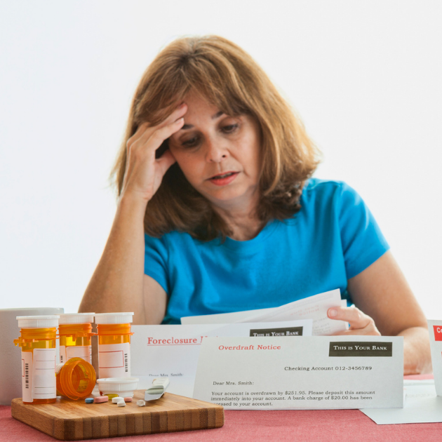 Woman with prescription drug bottles and medical bills